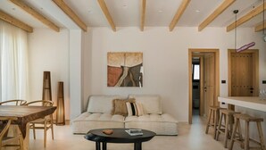 A spacious living area with a sofa, coffee table, and wooden furniture.