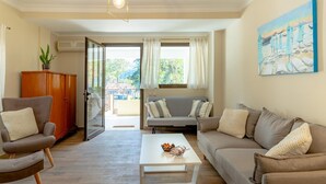 A living room with a sofa, armchairs, a coffee table, and a painting on the wall. - Entheos City Center Kefalonia (Kefalonia)