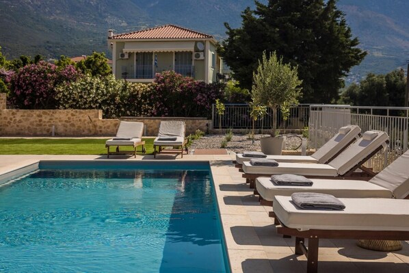 A pool area with lounge chairs and a building in the background.