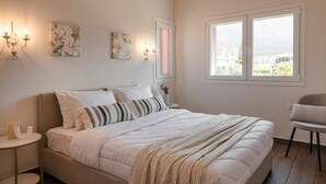 Une chambre à coucher comprenant un lit, des tables de chevet, des lampes fixées au mur et une fenêtre donnant sur un paysage agréable.