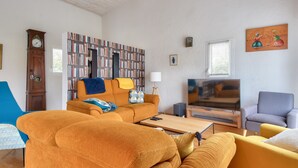 Ein Wohnzimmer mit einer Couch, einem Sessel und einem Bücherregal.