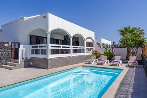 Un bâtiment moderne doté d’une piscine, d’un espace extérieur aménagé et d’un mur en pierre.