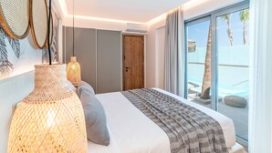 A modern bedroom with a large bed, a view of the pool, and a wooden door.