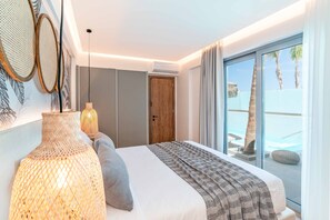 A modern bedroom with a large bed, a view of the pool, and a wooden door.