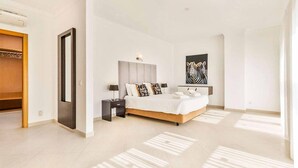 A modern bedroom with a large bed, bedside tables, a wardrobe, and a zebra artwork on the wall. - Villa Cabrita de Parra (Vale Rebelho)