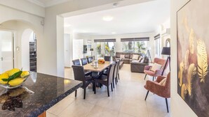 A spacious living area with a dining table, comfortable seating, and a large window providing natural light.