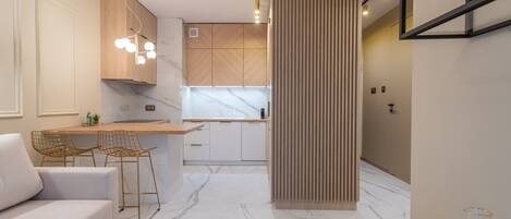 Una cocina moderna con encimeras de mármol, armarios de madera y una isla central.