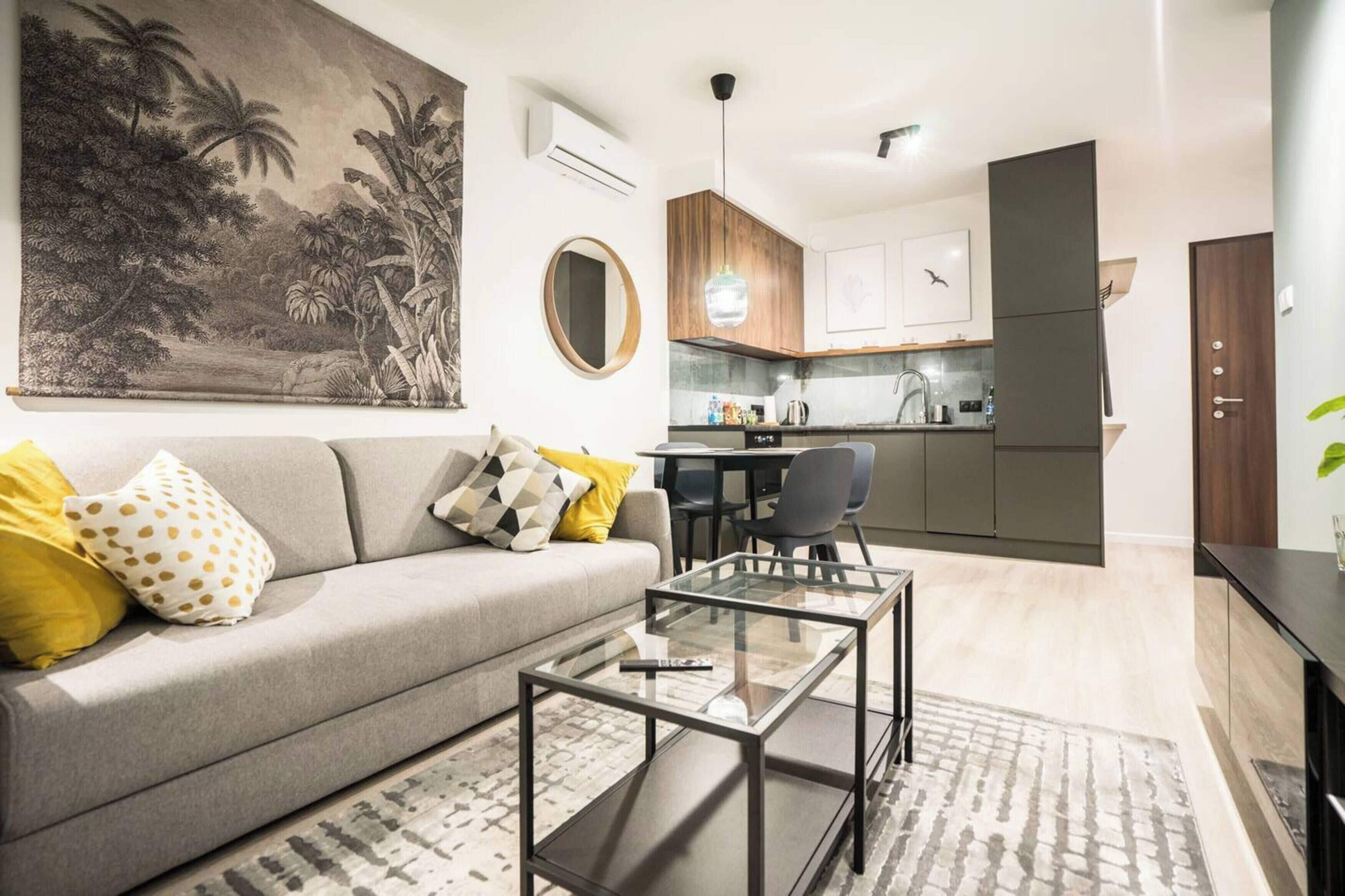 Un salon moderne avec un canapé, une table basse et un tableau accroché au mur.