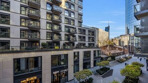 A modern urban building with multiple floors, large windows, and a café named 'café BUNCH' on the ground floor. - Vip Warsaw Apartments (Warsaw)
