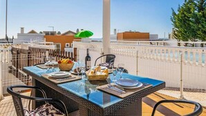 An outdoor dining area with a glass-top table set for two, surrounded by wicker chairs. - Casa Oliveira - Four Bedroom Villa, Sleeps 8 (Albufeira)