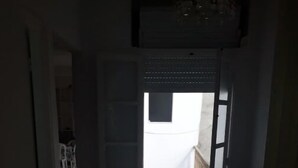 An open door leading to a balcony with a wooden floor and a white wall. - Dar Tobbel Borj Errass Mahdia (Mahdia)