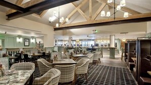A restaurant with a checkered floor, wooden beams, and plaid chairs. - The Queen Hotel Wetherspoon (Aldershot)