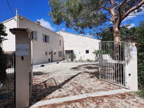 A building with a stone facade, a gated entrance, and a clear sky.