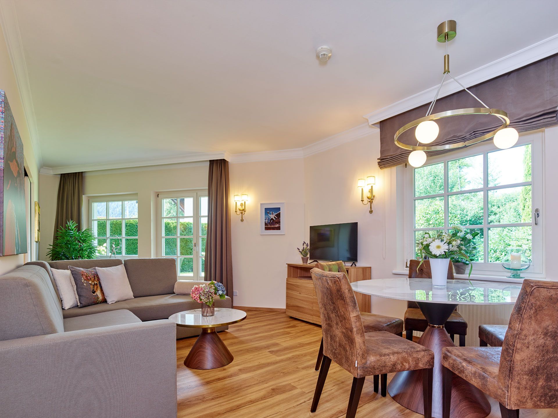 Een moderne woonkamer met een bank, een salontafel en een eethoek met stoelen.