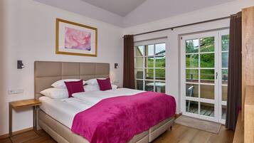 A bedroom with a bed, a nightstand, a window with curtains, and a door leading outside.