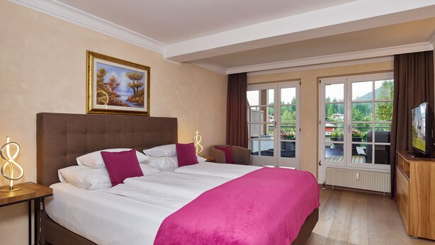 A hotel room with a large bed, a television, and a view of the outdoors through a glass door. - A-VITA Viktoria Residenzen (Seefeld in Tirol)