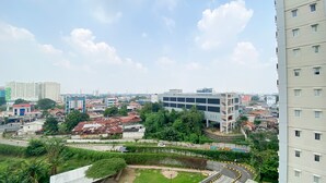 A cityscape with modern and traditional buildings, a curved road, and greenery. - Comfort And Good Choice 2Br Signature Park Grande Apartment (Jakarta)
