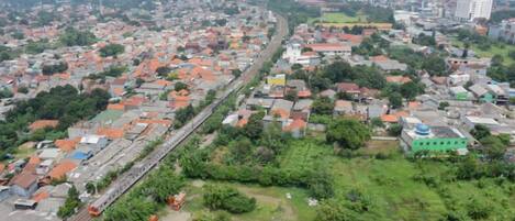 Vista aérea de una zona urbana densamente poblada con una vía ferroviaria que la atraviesa.