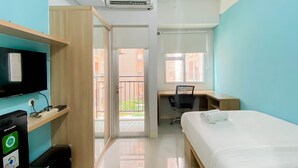 A modern hotel room with a bed, a desk, a TV, and a balcony. - Minimalist Studio Apartment At Transpark Juanda Bekasi Timur (Bekasi)