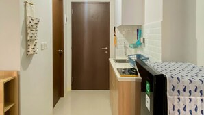 A compact kitchen with a refrigerator, sink, and cabinets. - Minimalist Studio Apartment At Transpark Juanda Bekasi Timur (Bekasi)