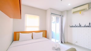 A hotel room with a bed, a window, an air conditioning unit, and a cityscape wall decal. - Minimalist And Nice Studio Apartment Atlanta Residence (Depok)