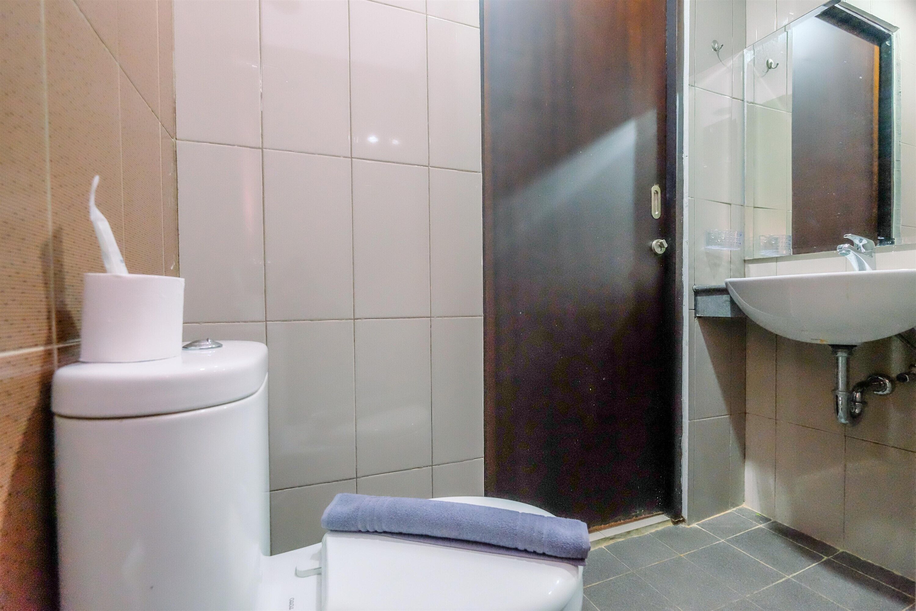 Ein Badezimmer mit Toilette, Waschbecken und Spiegel.