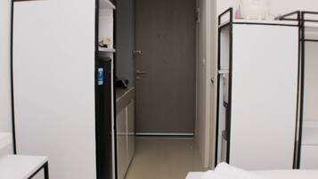 Una habitación de hotel con cama, escritorio y armario.