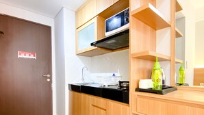 Een moderne keuken met houten kastjes, een magnetron, een spoelbak en een fornuis.