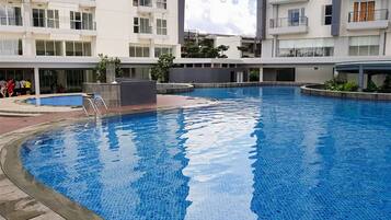 A modern residential building with a swimming pool.