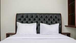A bed with a tufted headboard, two white pillows, and a white bedspread. - Comfort And Cozy Stay 2Br At 29Th Floor Transpark Cibubur Apartment (Depok)
