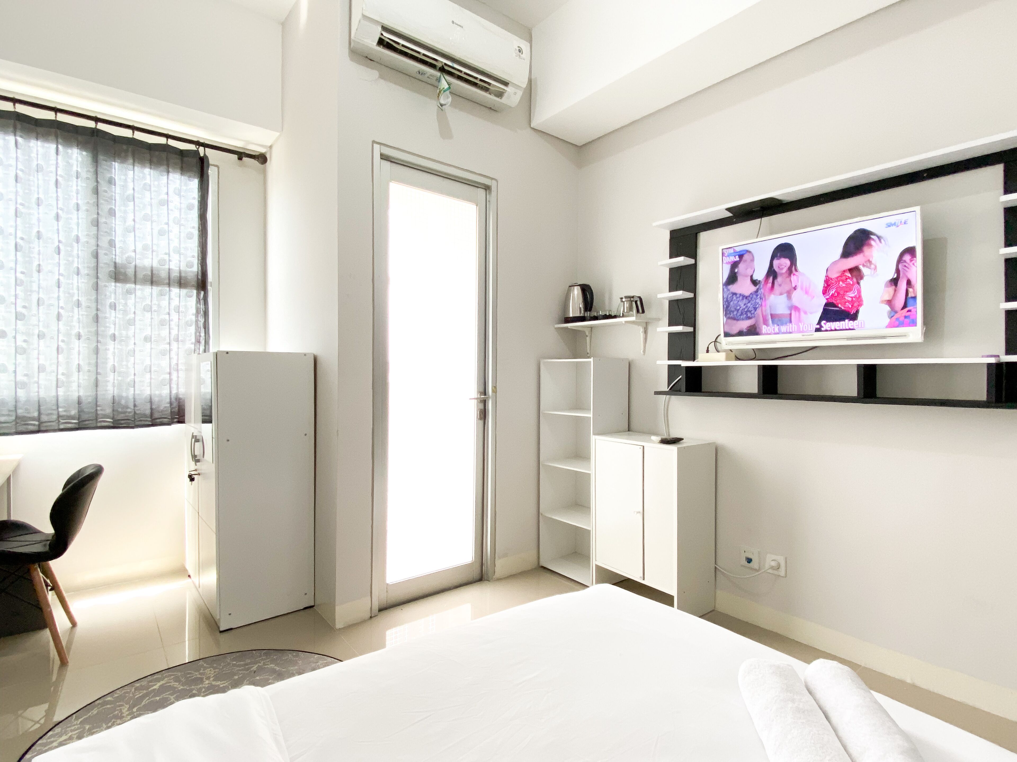 Une chambre d’hôtel moderne équipée d’un lit, d’un téléviseur fixé au mur, d’une armoire, d’un bureau et d’une chaise.