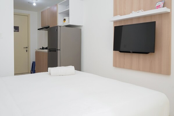 Relax in a spacious room with a large bed, flat-screen TV, and compact kitchenette.