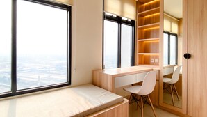 Ein modernes Schlafzimmer mit großem Fenster, integriertem Schreibtisch und einer Schrankwand mit Regalen.