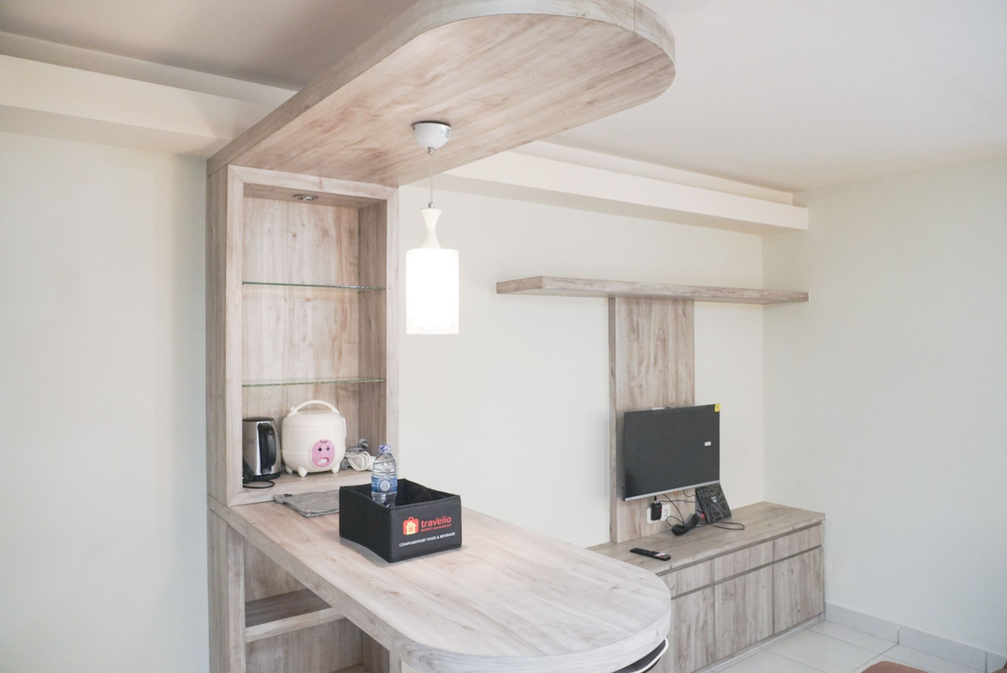 A modern kitchen with a wooden countertop, a built-in microwave, a toaster, and a water dispenser.