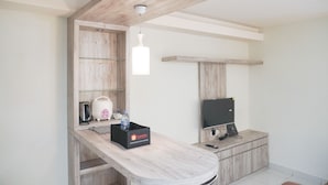 Una cocina moderna con encimera de madera, microondas integrado, tostadora y dispensador de agua.
