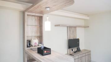 A modern kitchen with a wooden countertop, a built-in microwave, a toaster, and a water dispenser.
