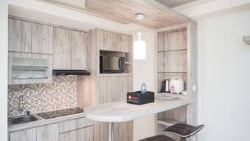 A modern kitchen with wooden cabinets, a microwave, a toaster, and a water dispenser on a countertop.