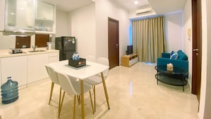 A compact living space with a kitchenette, a dining area, a sofa, and a TV. - Best Location 2Br Apartment At Capitol Park Residence (Jakarta)