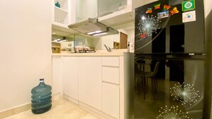 A modern kitchen with white cabinets, a stainless steel refrigerator, and a water dispenser. - Best Location 2Br Apartment At Capitol Park Residence (Jakarta)