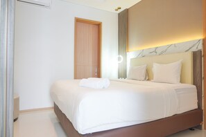 A neatly made bed with white linens and a rolled towel, a wooden door, and a marble-patterned wall with a light fixture. - Comfort And Modern Look 2Br At 26Th Floor Samara Suites Apartment (Jakarta)