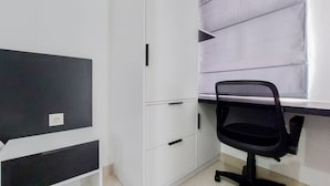 A room with a desk, a chair, and a wardrobe.