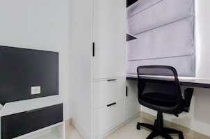 A room with a desk, a chair, and a wardrobe.