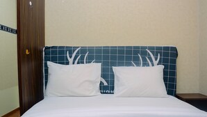 A bed with white bedding and two white pillows with antler designs. - Beautiful 2Br With Direct Access To Pool Green Bay Pluit Apartment (Jakarta)