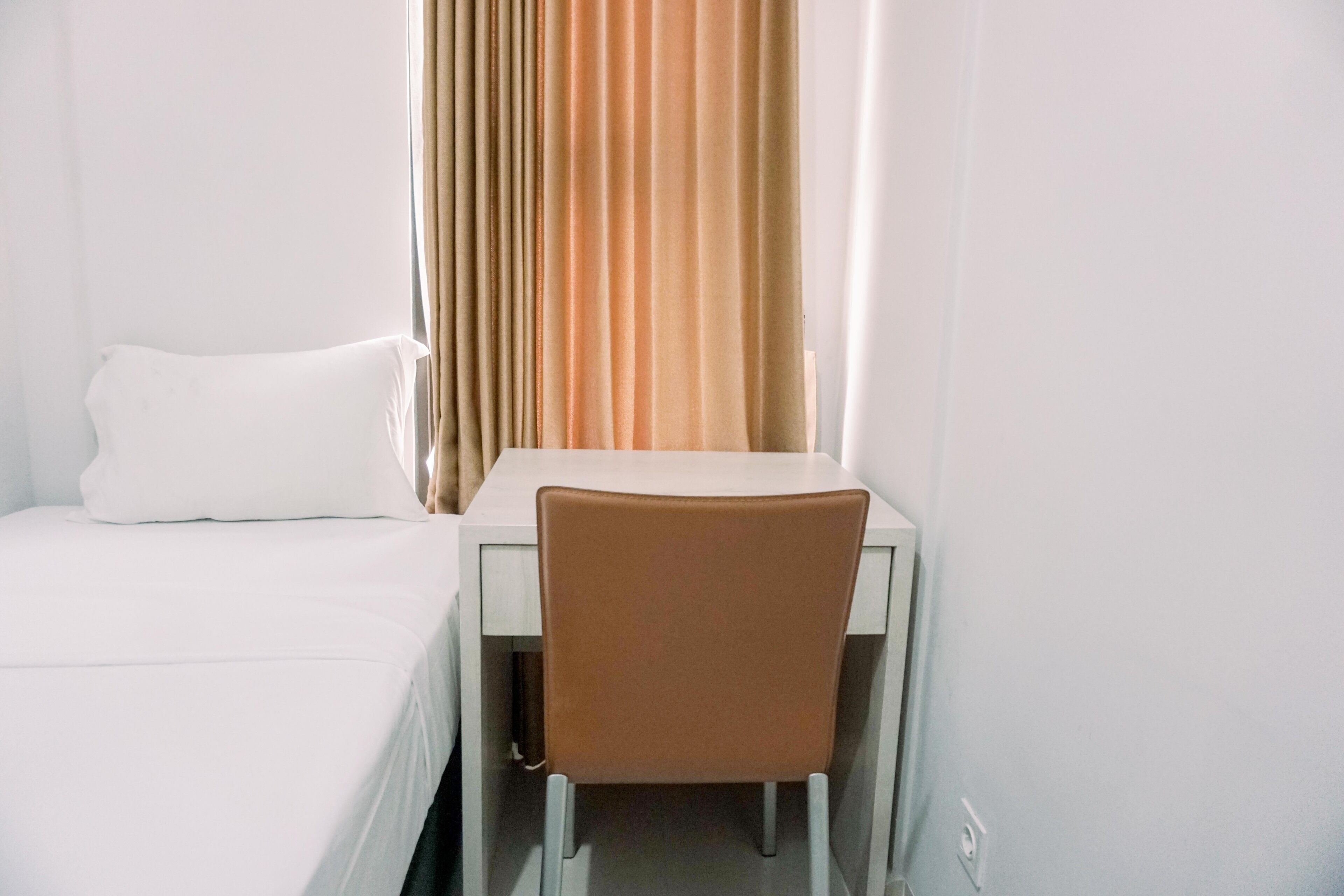 Une chambre d’hôtel avec un lit, un bureau et une chaise.