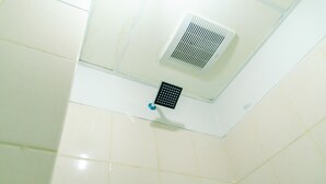 A bathroom with white tiles, a showerhead, and a ventilation unit. - Cozy Living Studio Room At Serpong Greenview Apartment (South Tangerang)