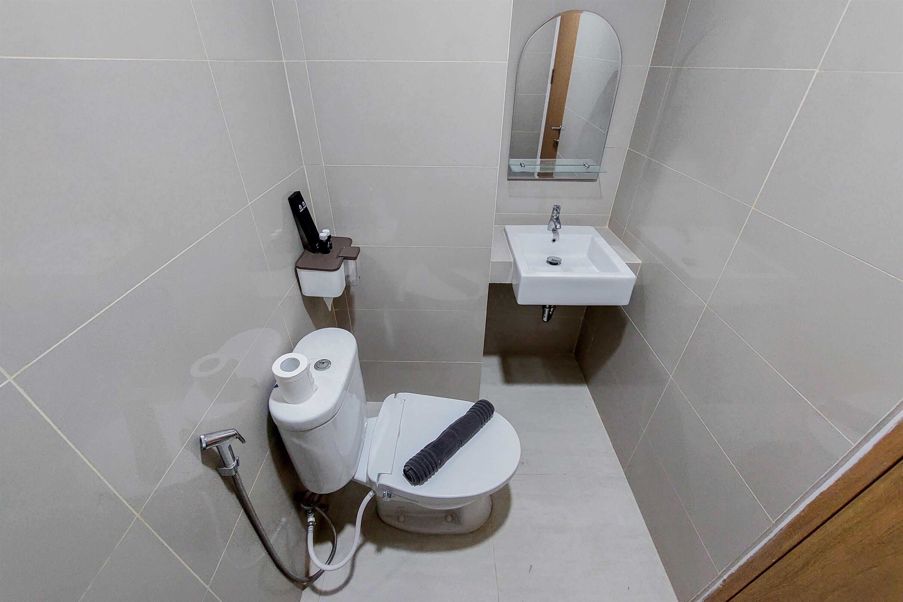 A small, modern bathroom with a toilet, bidet, and sink.