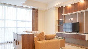 A modern living room with a sofa, a TV, and a wooden cabinet.