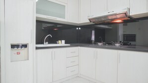 Een moderne keuken met witte kasten, een zwart aanrecht, een roestvrijstalen spoelbak en een inbouwoven.