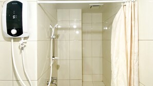 Un baño con ducha, panel de control y cortina.
