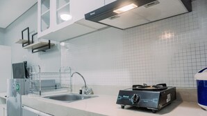 Moderni keittiö, jossa on kaasuliesi, pesuallas ja ruostumattomasta teräksestä valmistetut kodinkoneet.
